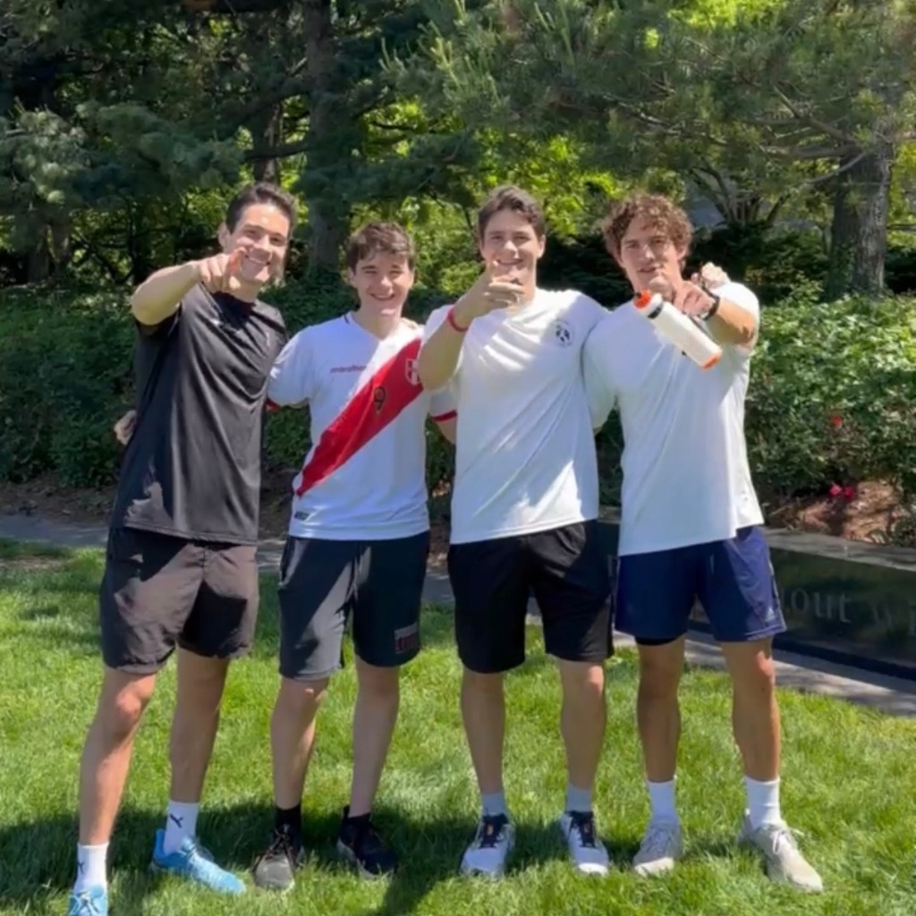 Alex, Felix, and friends posing together on the grass